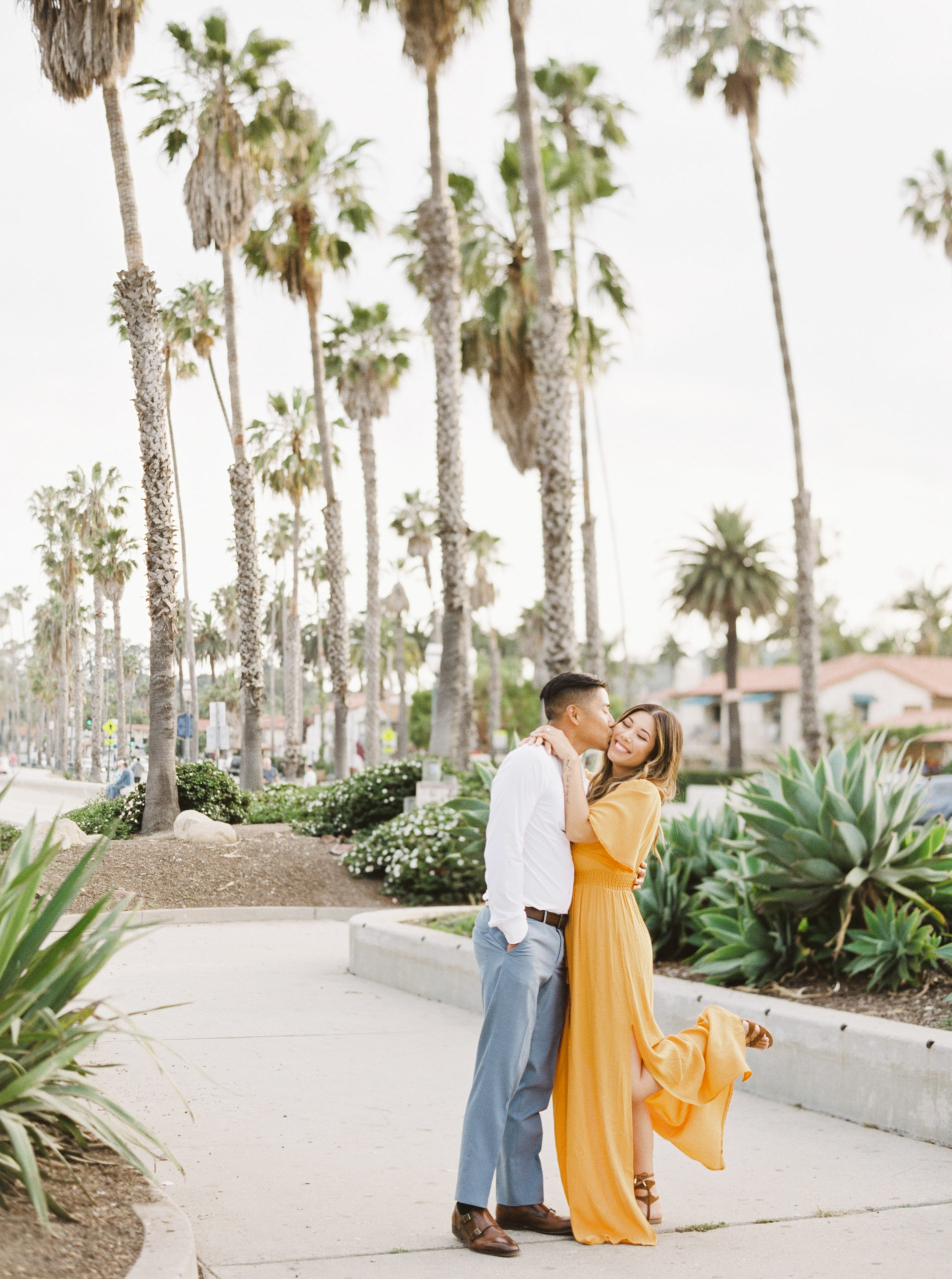 Couple in love, kissing in the streets of Santa Barbara for their honeymoon photos